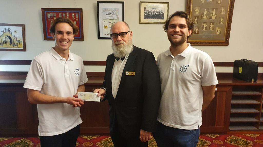 three men holding a cheque for $1000 for charity