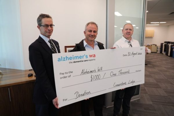 three men holding a cheque for $1000 for charity